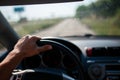 A man driving a car, focus on the left hand held on steering wheel Royalty Free Stock Photo