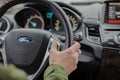 Man driving car Ford Fiesta. Auto interior. Man hand on steering wheel. Auto dashboard. Journey concept.