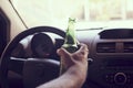 Man driving a car while holding a bottle of beer. Drunk diving, unsafe driving concept Royalty Free Stock Photo