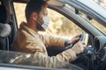 a man driving a car puts on a medical mask during an epidemic, a taxi driver in a mask, protection from the virus