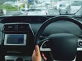 Man driving car from rear view on the highway. Driver`s hands on the steering wheel inside of a car