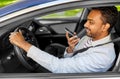 man driving car and recording voice by smartphone