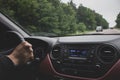 Man driving car. Red and black car interior. Driver in automobile with unfocused road on background. Dashboard of car. Royalty Free Stock Photo