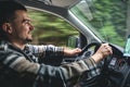 A man driving a car rides in a mountainous forest area. Royalty Free Stock Photo