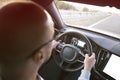 Man driving a car. Success in motion. Handsome young man driving a car. A man holds the steering wheel of a car