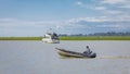 Man driving a fast boat in natural background. Fisherman on boat fishing along coast Royalty Free Stock Photo