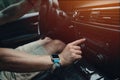 Man driving his car and tuning radio, smart watch on the hand, inside