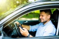 Young man driving in his car using cell mobile phone, dangerous situation Royalty Free Stock Photo