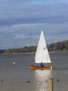 A man is driving his little sailboat over the water