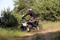 Man driving modern quad bike on sandy road near forest. Extreme sport Royalty Free Stock Photo