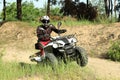 Man driving modern quad bike on sandy road near forest. Extreme sport Royalty Free Stock Photo