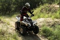 Man driving modern quad bike on sandy road near forest. Extreme sport Royalty Free Stock Photo