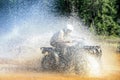 Man driving motocross ATV quad through splashing river lake water with high speed. Foy, Foyross Lake, Sudbury, Canada. Royalty Free Stock Photo