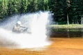 Man driving motocross ATV quad through splashing river lake water with high speed. Foy, Foyross Lake, Sudbury, Canada. Royalty Free Stock Photo