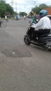 A man driving motorcycle by wearing blue helmet