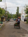 a man driving a rickshaw on a quiet little street