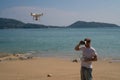 Man with drone camera and virtual reality glasses taking photos and videos on the beach Royalty Free Stock Photo