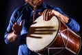 Man is drumming on wooden ethnic drum