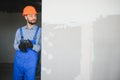 man drywall worker installing plasterboard sheet to wall Royalty Free Stock Photo