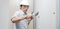 Man drywall worker or plasterer putting plaster on plasterboard wall using a trowel and a spatula, fill the screw holes, wearing