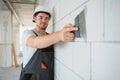 man drywall worker using trowel for plasterer putting stucco on plasterboard white wall Royalty Free Stock Photo