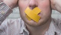 A man with duct tape on his mouth  a man with duct tape on his lips. The man's mouth is closed. Royalty Free Stock Photo