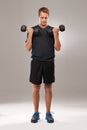 Man, dumbbells and weightlifting fitness in studio or exercise performance, training or grey background. Male person Royalty Free Stock Photo