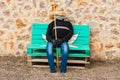 Man dummy, representing a farmer or a fisherman, sitting on the bench with a stone wall in the background Royalty Free Stock Photo