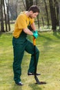 Man in dungarees digging in garden