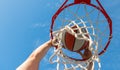 man dunking basketball ball through net ring with hands, sport