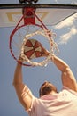 man dunking basketball ball through net ring with hands, sport success Royalty Free Stock Photo
