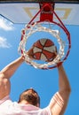 man dunking basketball ball through net ring with hands, success Royalty Free Stock Photo