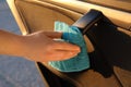 Man with duster sanitizing car door handle outdoors, closeup Royalty Free Stock Photo