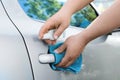Man with duster and spray sanitizing car door handle outdoors, closeup Royalty Free Stock Photo