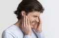 Man with earache is holding sore spot