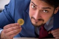 Young man earning money via Internet in cryptocurrency concept Royalty Free Stock Photo