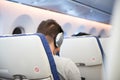 Man with earphone sit inside airplane while travel abroad.