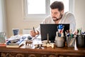 Man with earphones having conference call online sitting at home office with laptop