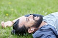 Man with earphones listening to music on grass Royalty Free Stock Photo