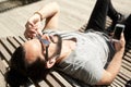 Man with earphones and smartphone on city bench Royalty Free Stock Photo