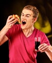 Man eat fast food pizza piece and drink cola glass