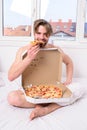 Man eat pizza breakfast. Guy naked covered pizza box sit bed bedroom offer you join him. courier delivers Royalty Free Stock Photo