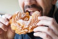 Man is eating a custard ring - a traditional Russian dessert