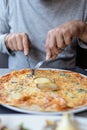 Man eating delicious cheesy pizza in the restaurant with fork and knife Royalty Free Stock Photo