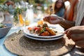 Man eating delicious grilled food with fresh vegetable salad. Preparing meals, refreshments for garden party. Outdoor