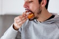 Man eating donut on breakfast at kitchen Royalty Free Stock Photo