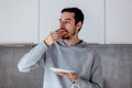 Man eating donut on breakfast at kitchen Royalty Free Stock Photo