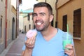 Man eating a Donuts and drinking a shake outdoors