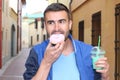 Man eating a Donuts and drinking a shake outdoors