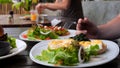 Man eating full meal as poached egg, salad and avocado toast in cafe. Close-up of man with fork pierces poached egg and Royalty Free Stock Photo